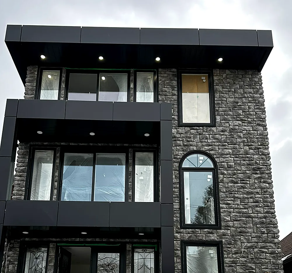 Black ACM panel bands and fascia over a stone veneer facade