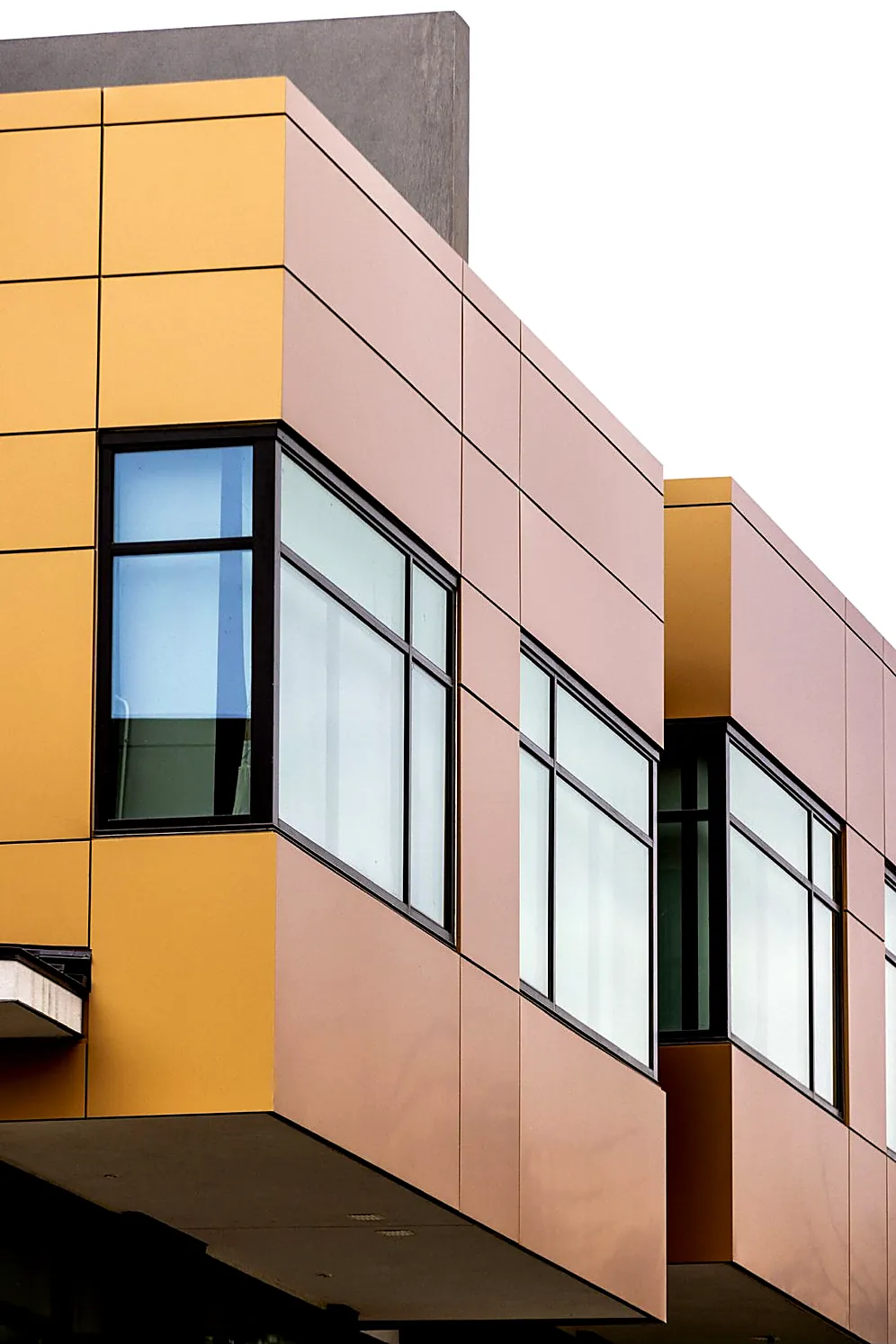 Copper and gold ACM panels on a cantilevered upper storey