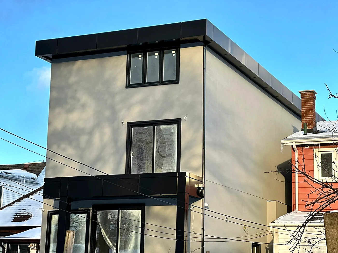 Stucco home with a black panel band and window surrounds